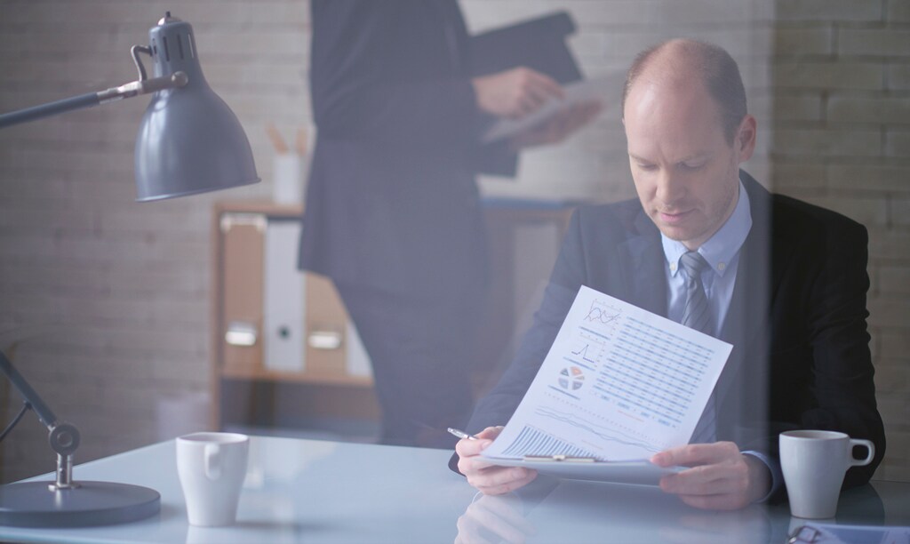 A man is looking at a report on CFO Salary